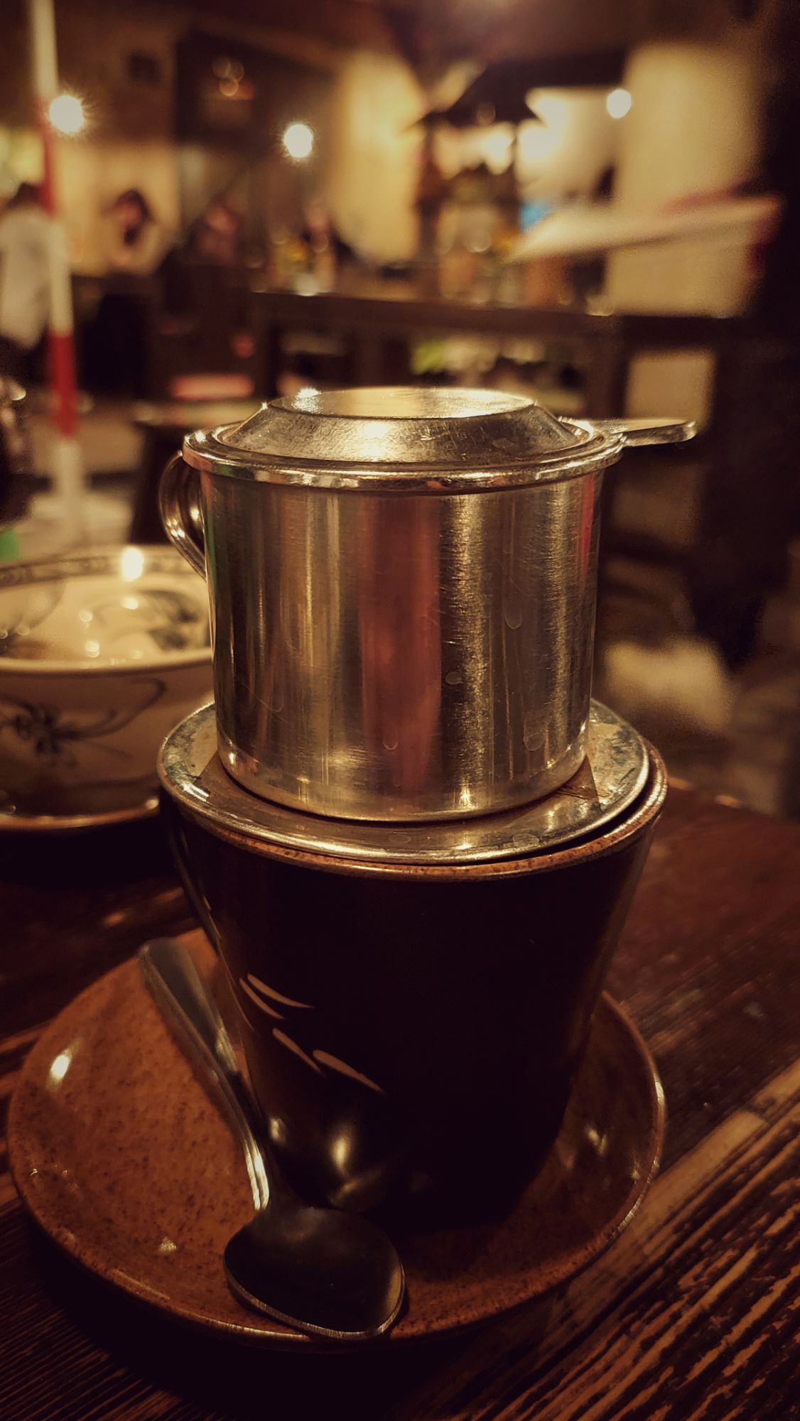 A vietnamese coffee can on a table of a restaurant.