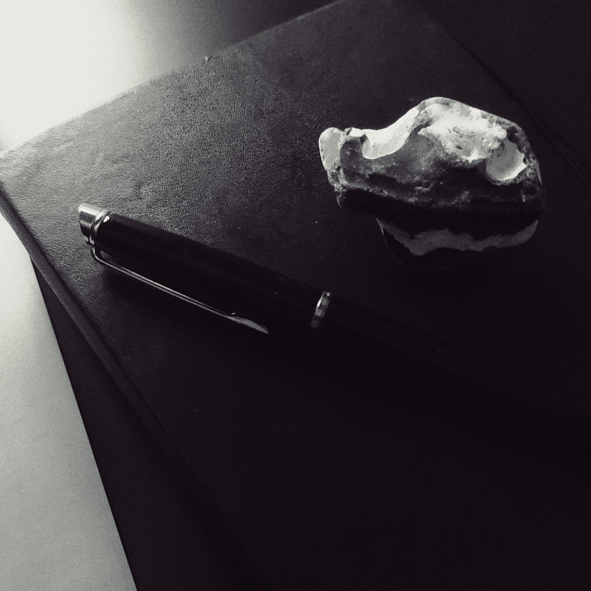 A pen and an island stone on a notebook surface.