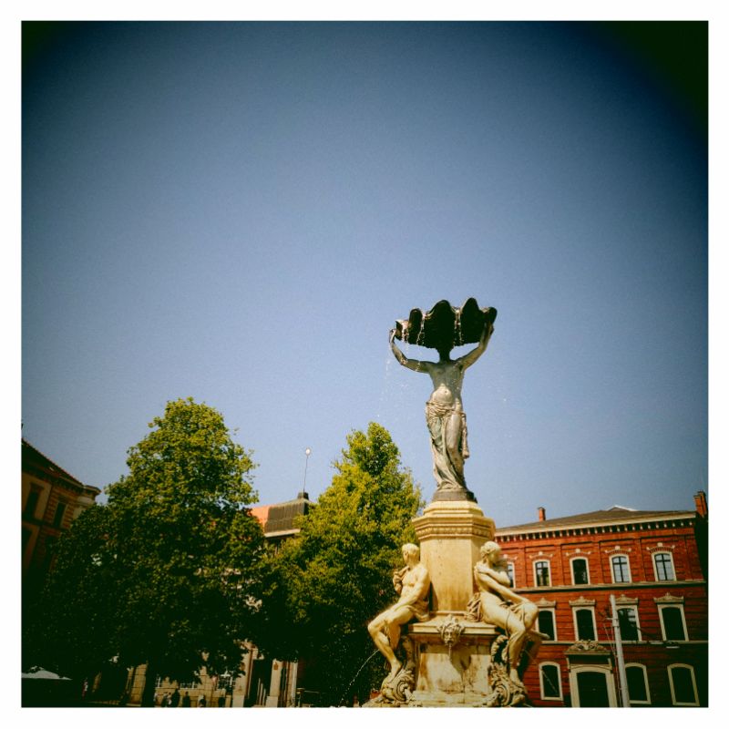 Top of an old fountain in front of blue sky.