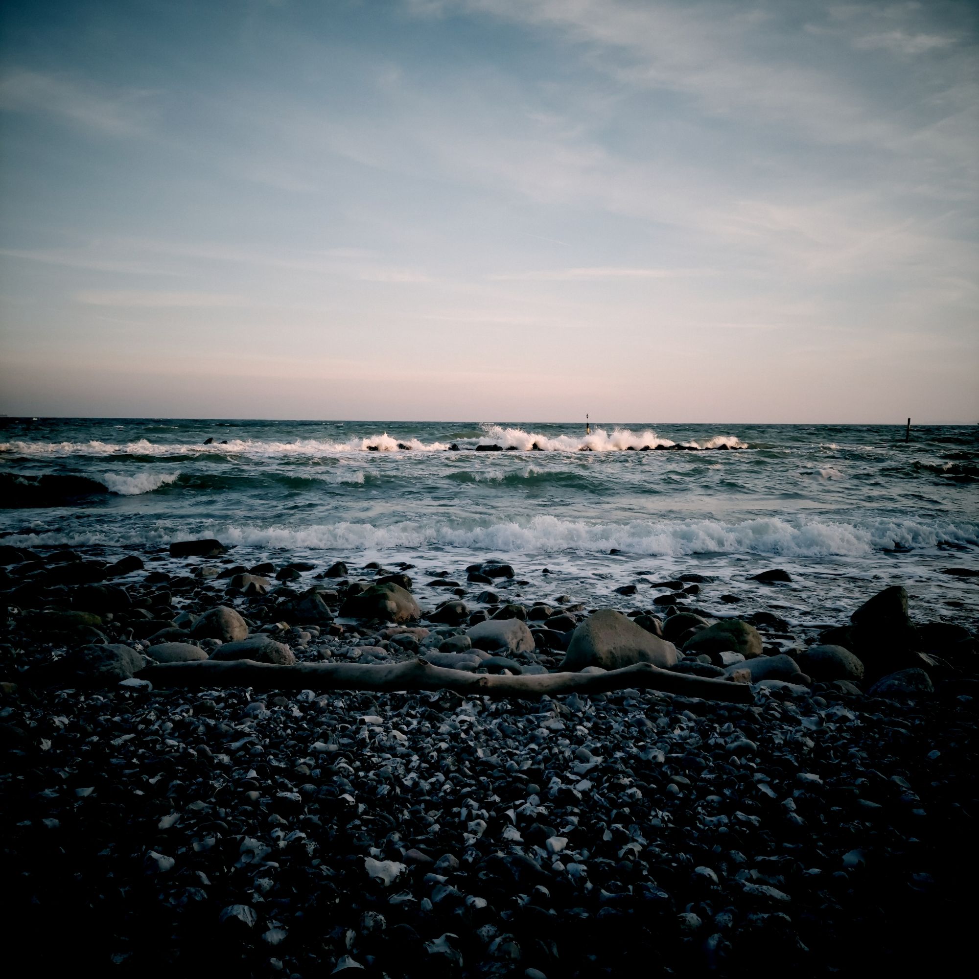 Rollende Wellen an einem Steinstrand.