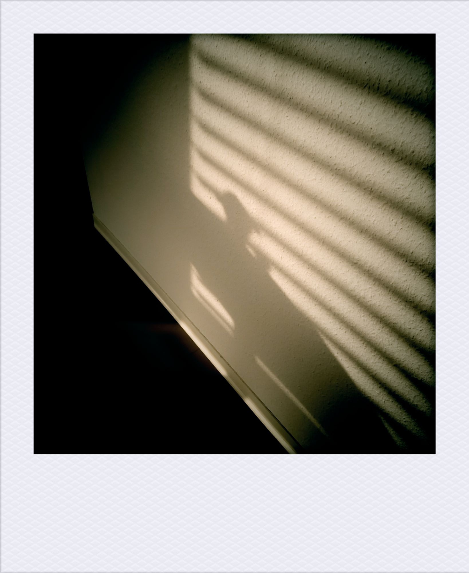 Schatten an einer anderen Wand: Lamellen hinter einem Fenster. Dinge auf einem Tisch. Darunter Fußboden.