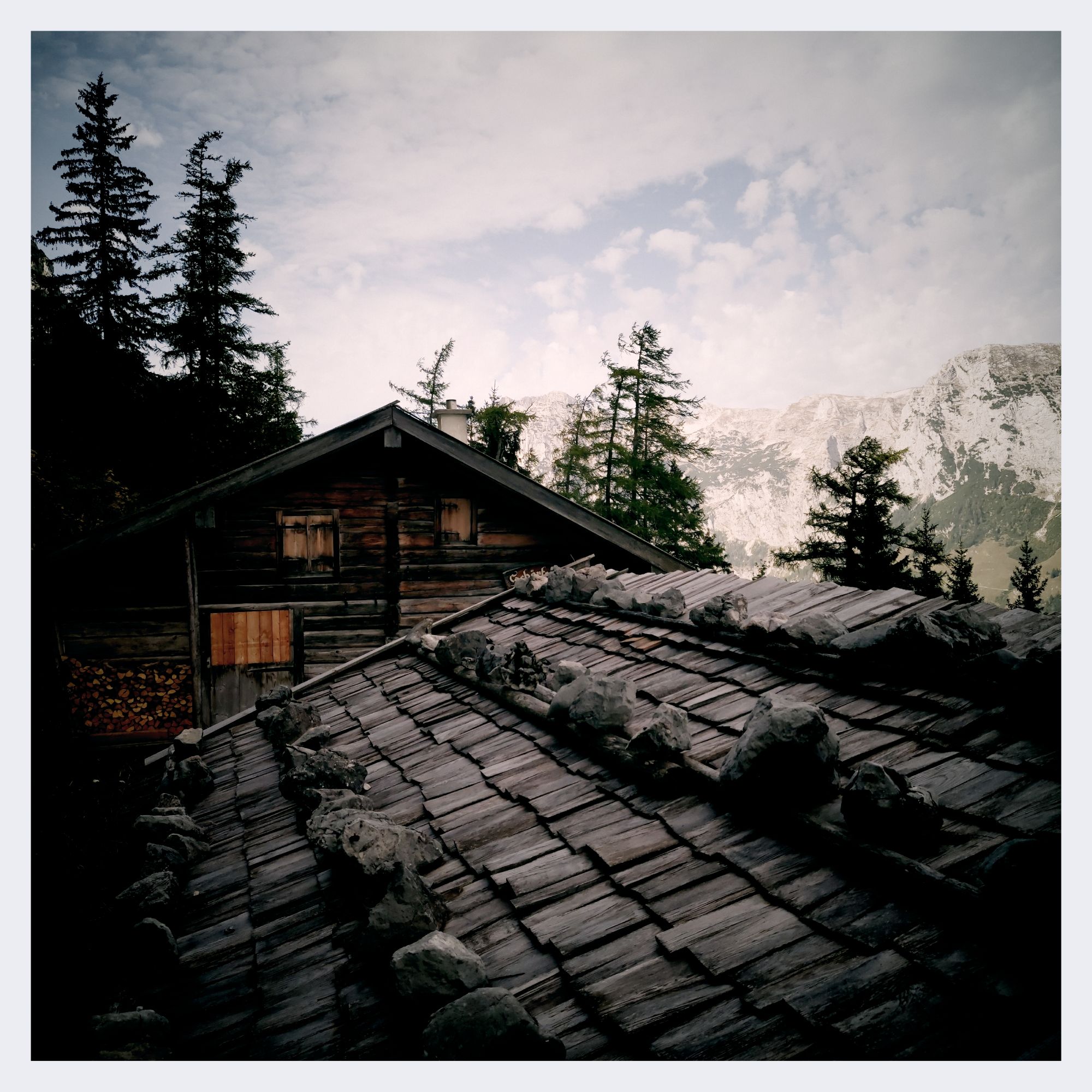 Roof of a mountain cottage, stones on shingles of wood.