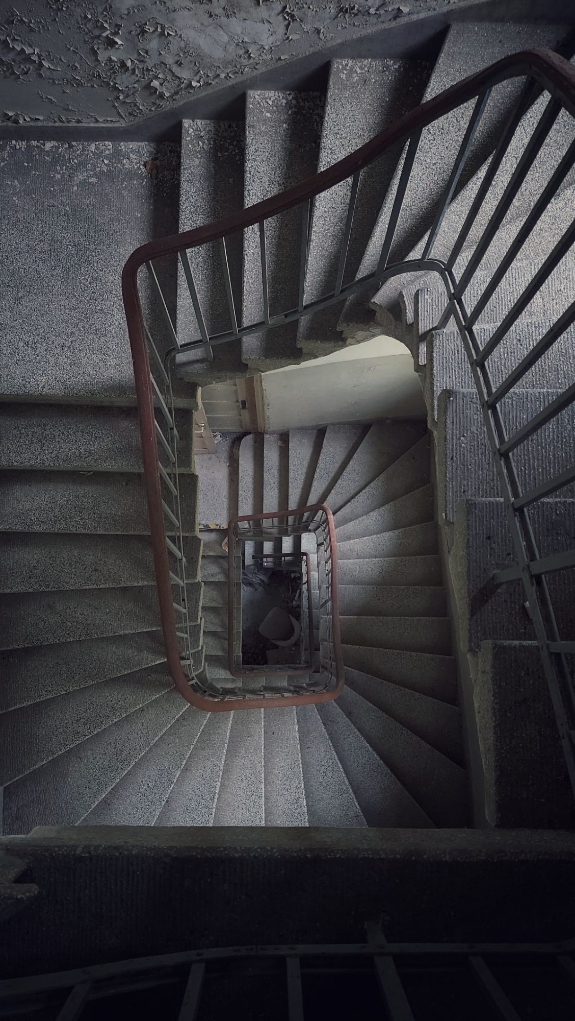 Looking down an abandoned spiral staircase. 