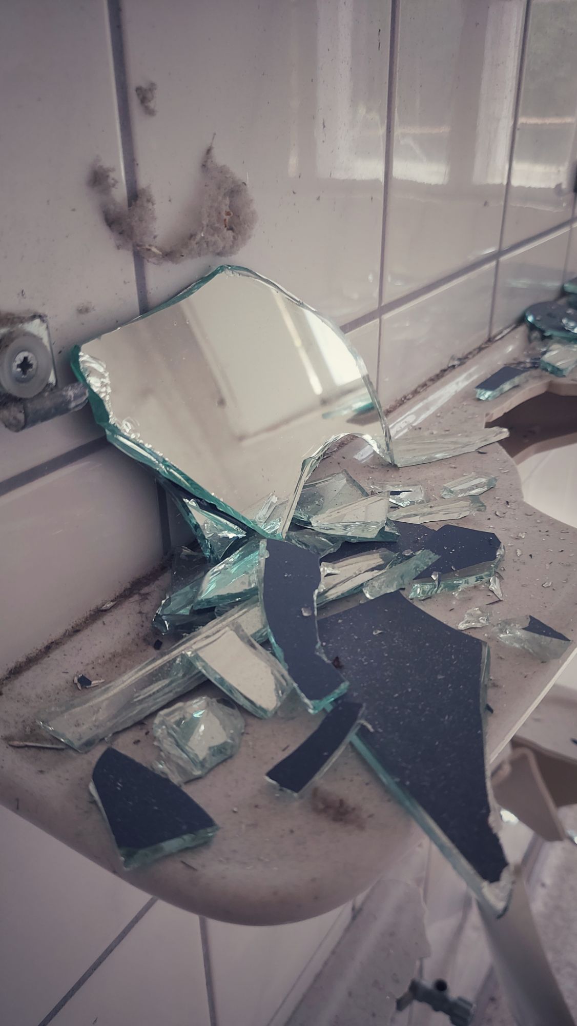 Shards of a mirror on a bathroom shelf.