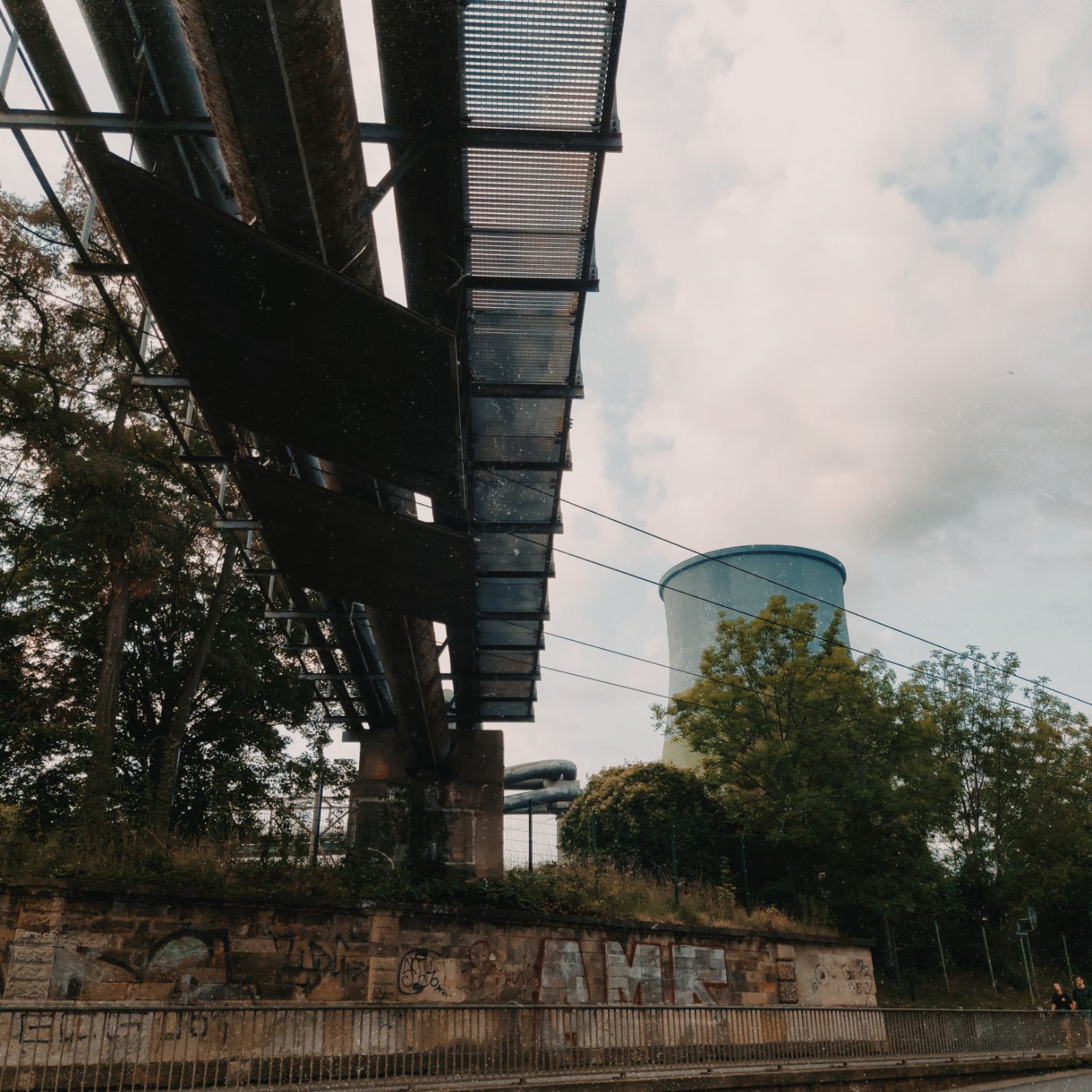 A power plant cooling tower and a bridge seen from below at a somewhat flaky angle.