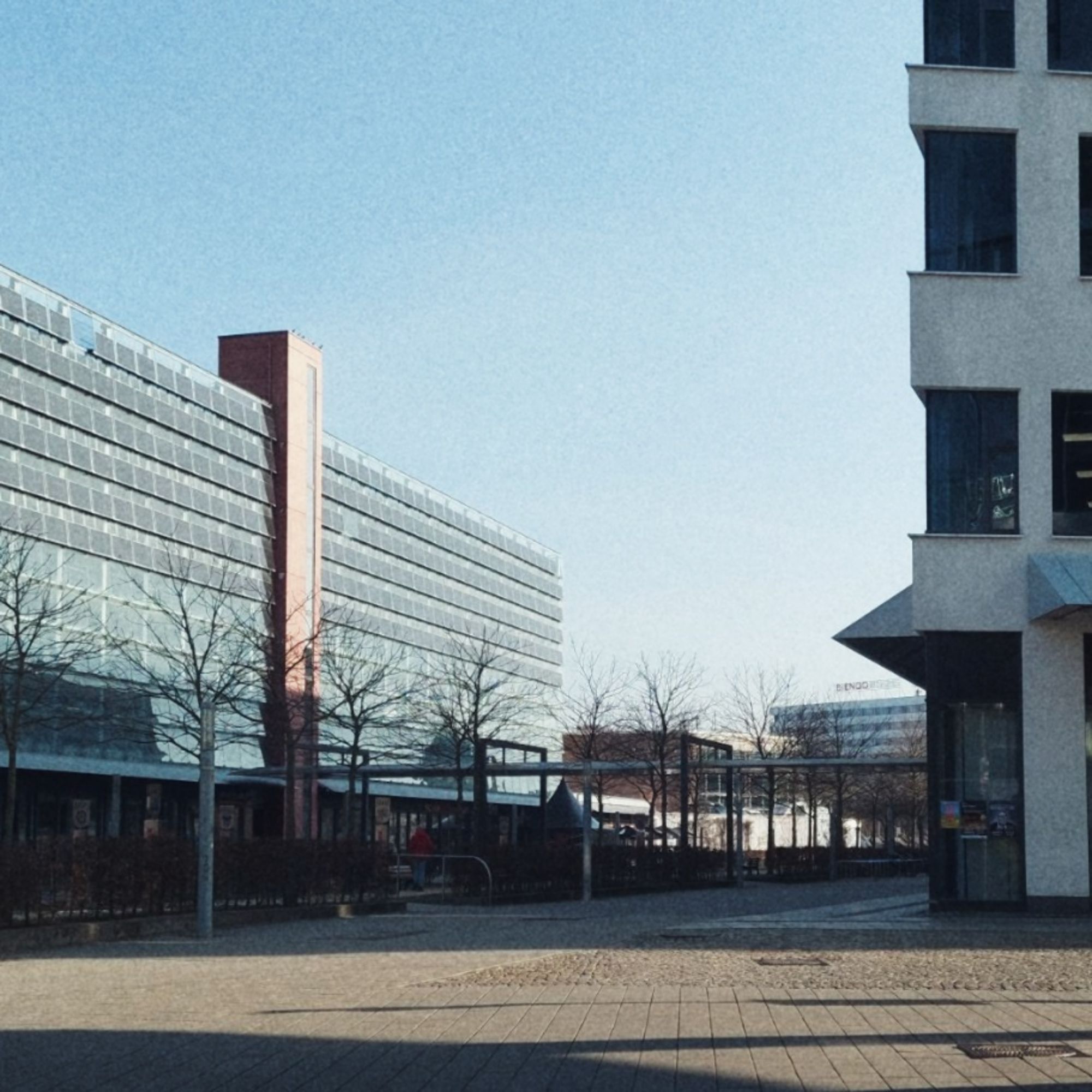 Moderne Architektur und eine leere Passage unter blassblauem Himmel. 