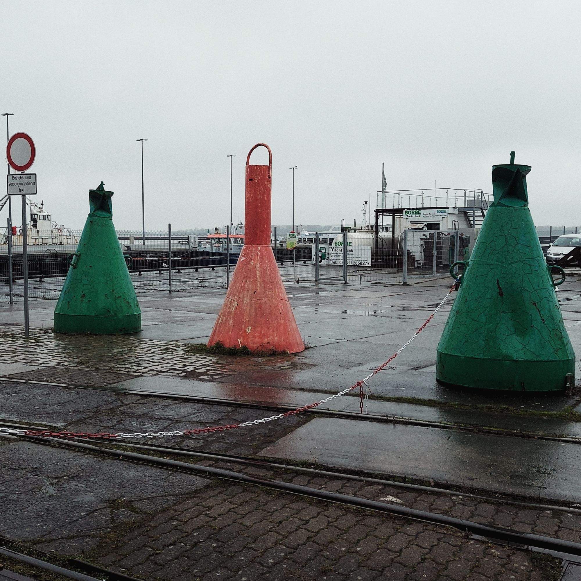 Three buoys along train tracks.
