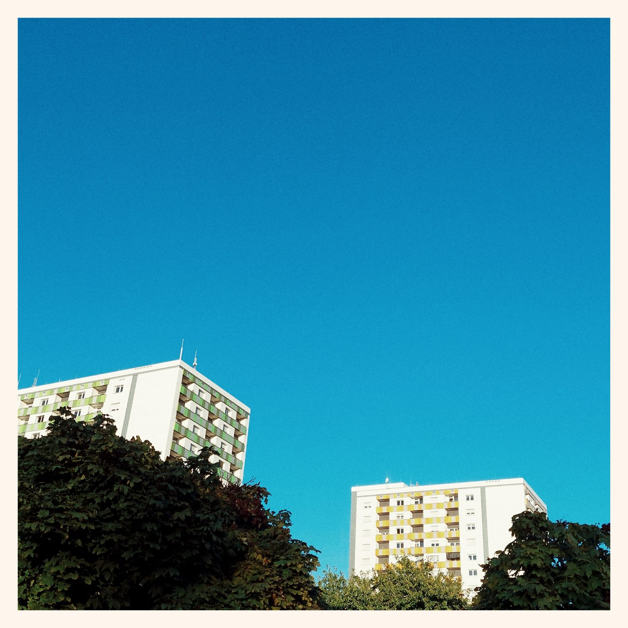 East modernist apartment buildings under a clear sky.