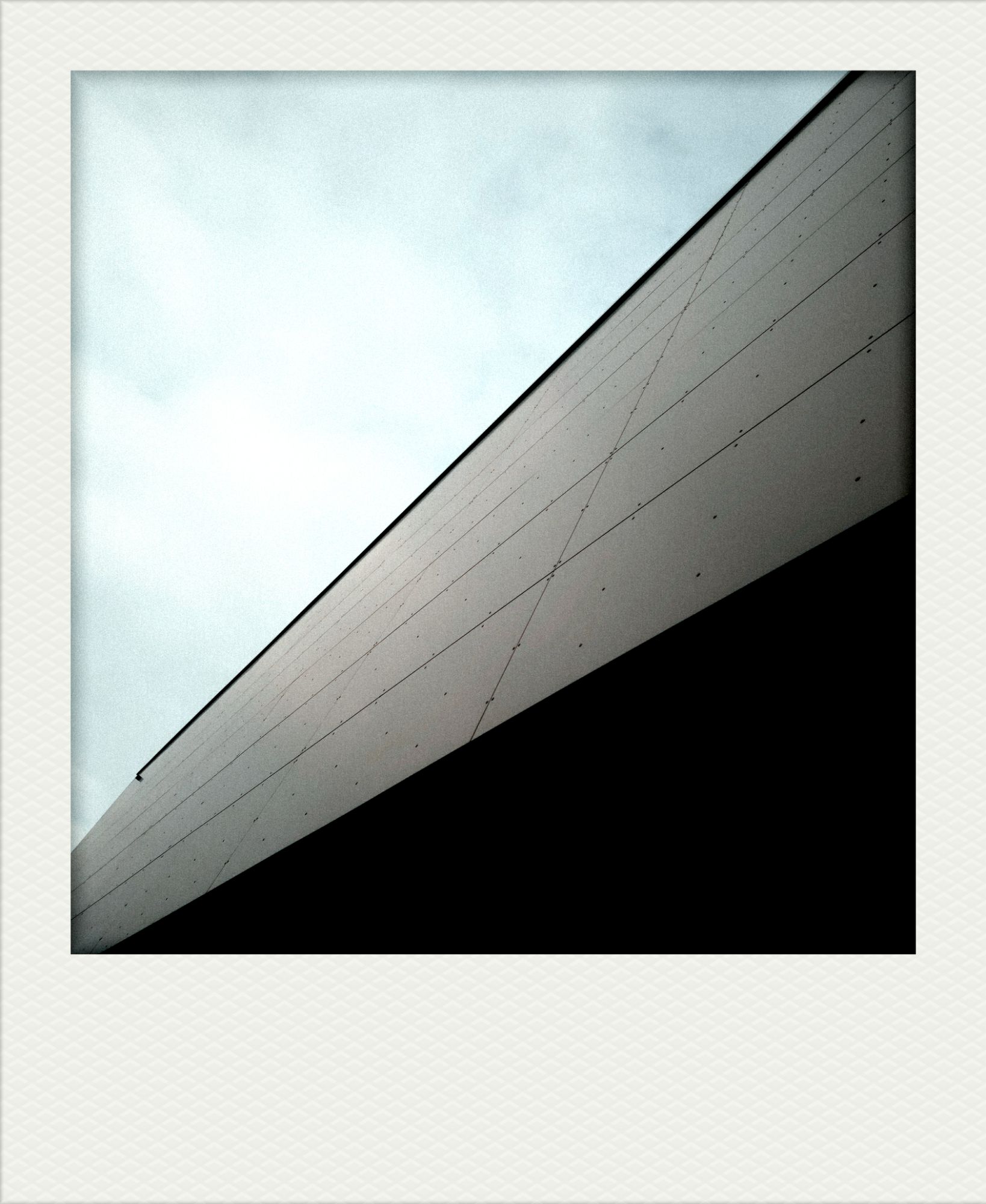 Wolkenhimmel über moderner Fassade.
