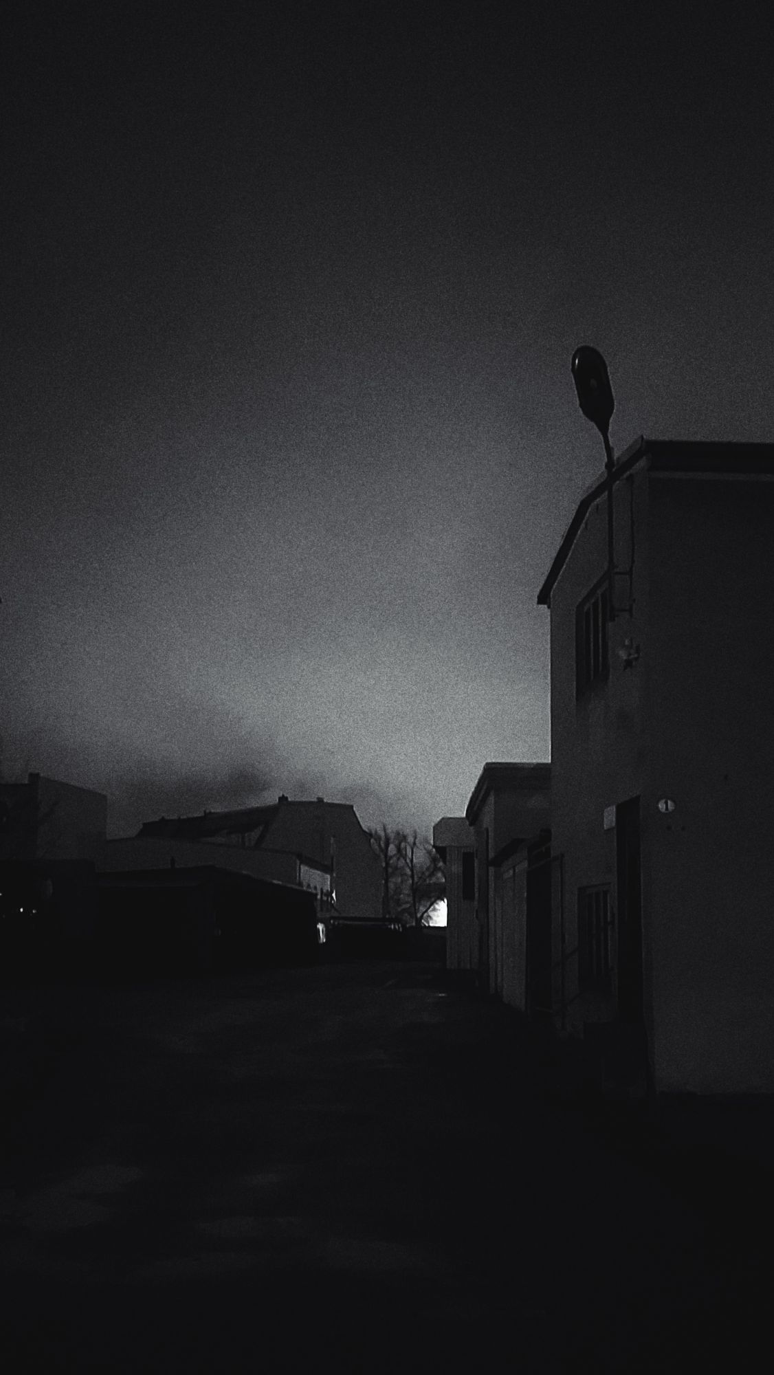 An abandoned industrial facility in early night. Monochrome shot.