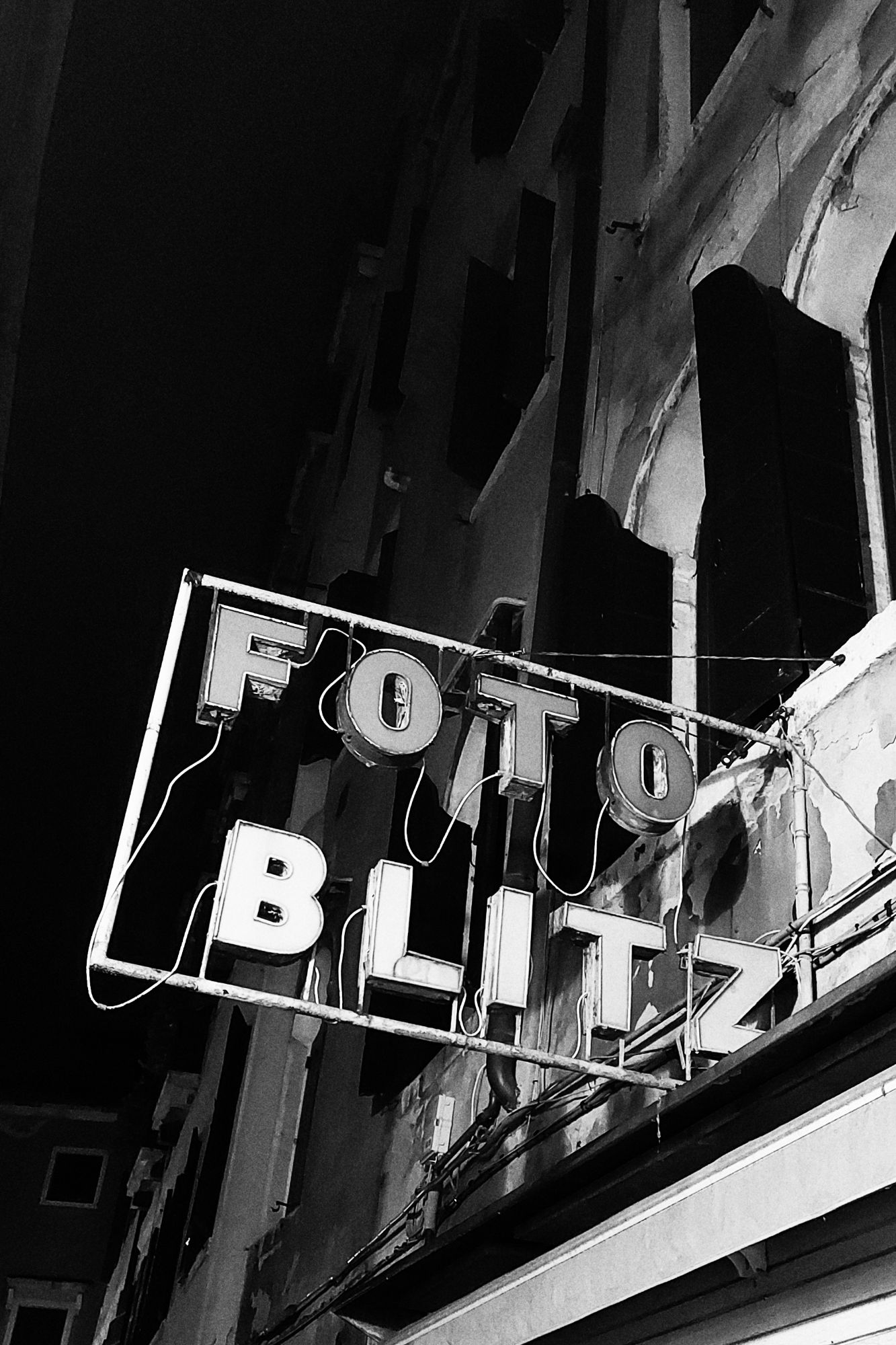 An old house facade with a defunct former neon advertisement reading FOTO BLITZ.