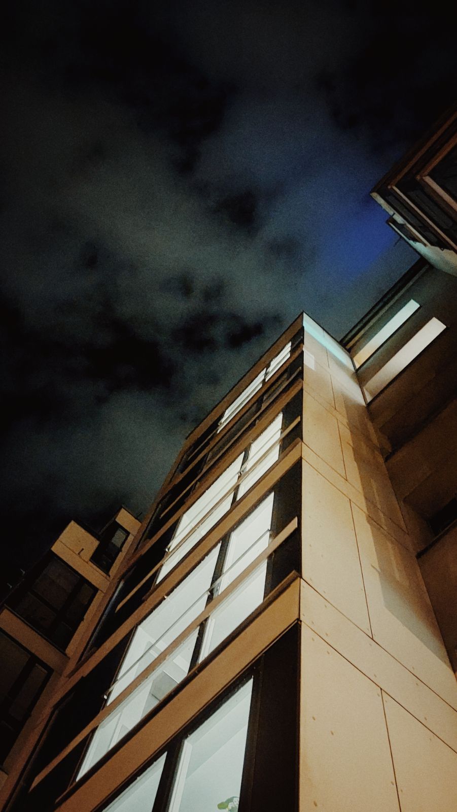 Lighted staircase of a high-rise at night. Troubled nightsky above.