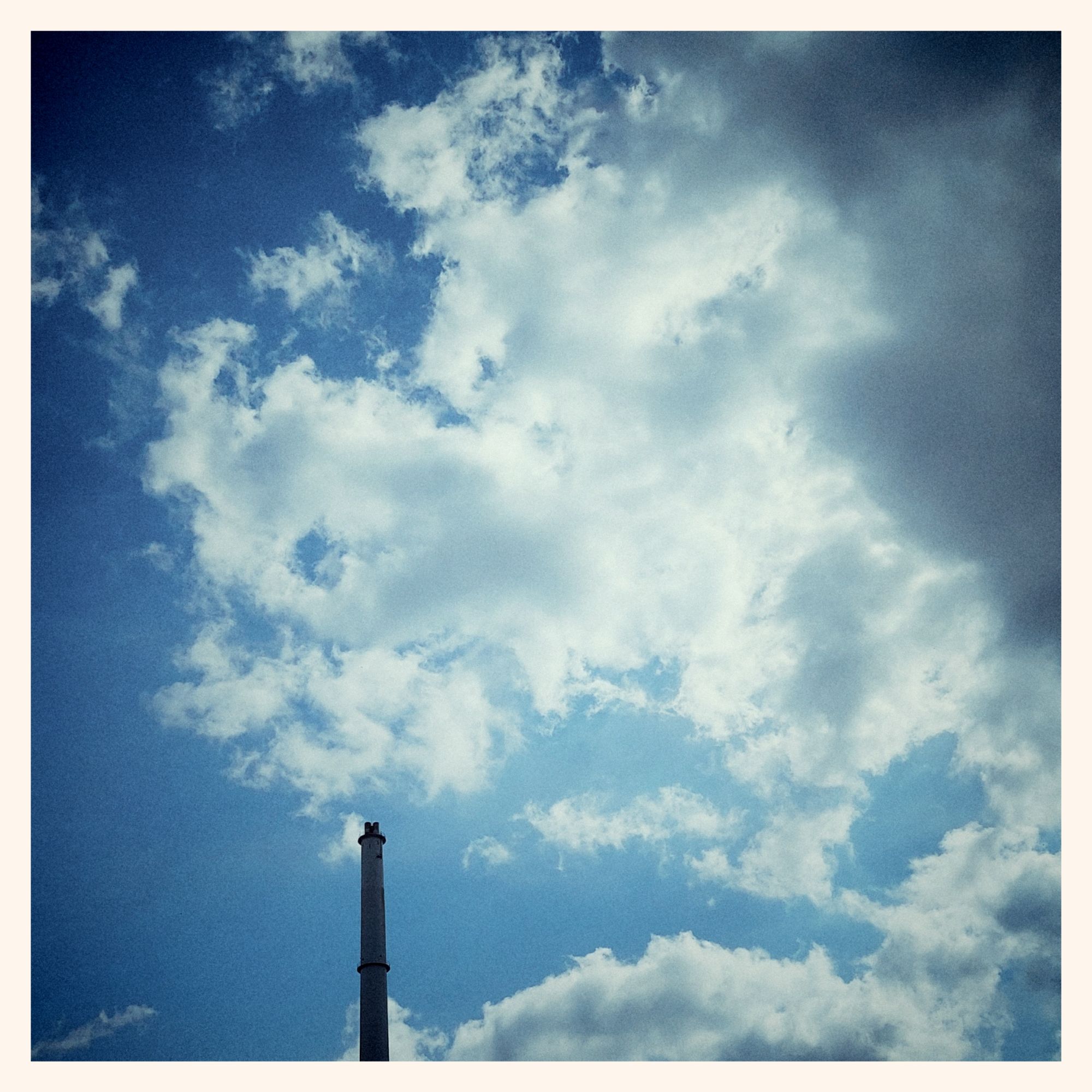 High clouds, blue sky and a factory chimney, elsewhere.