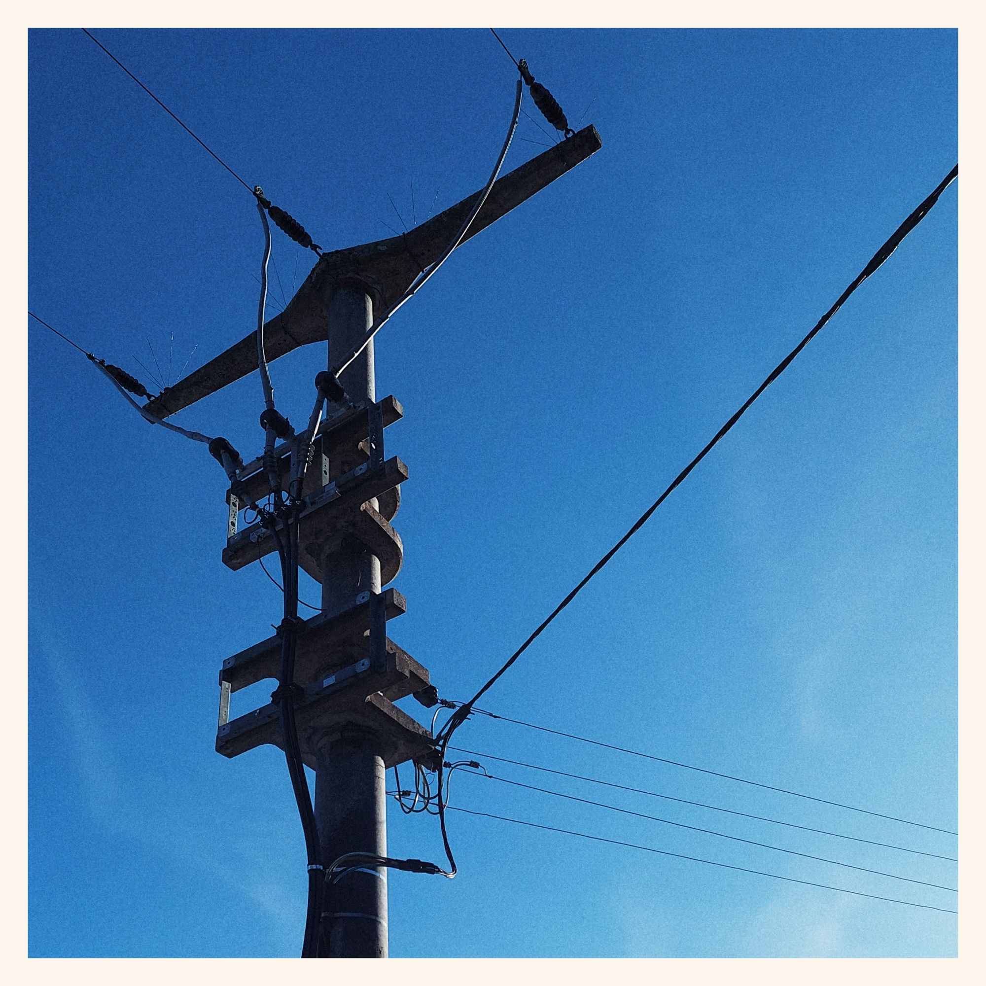 Powerlines in front of blue sky.