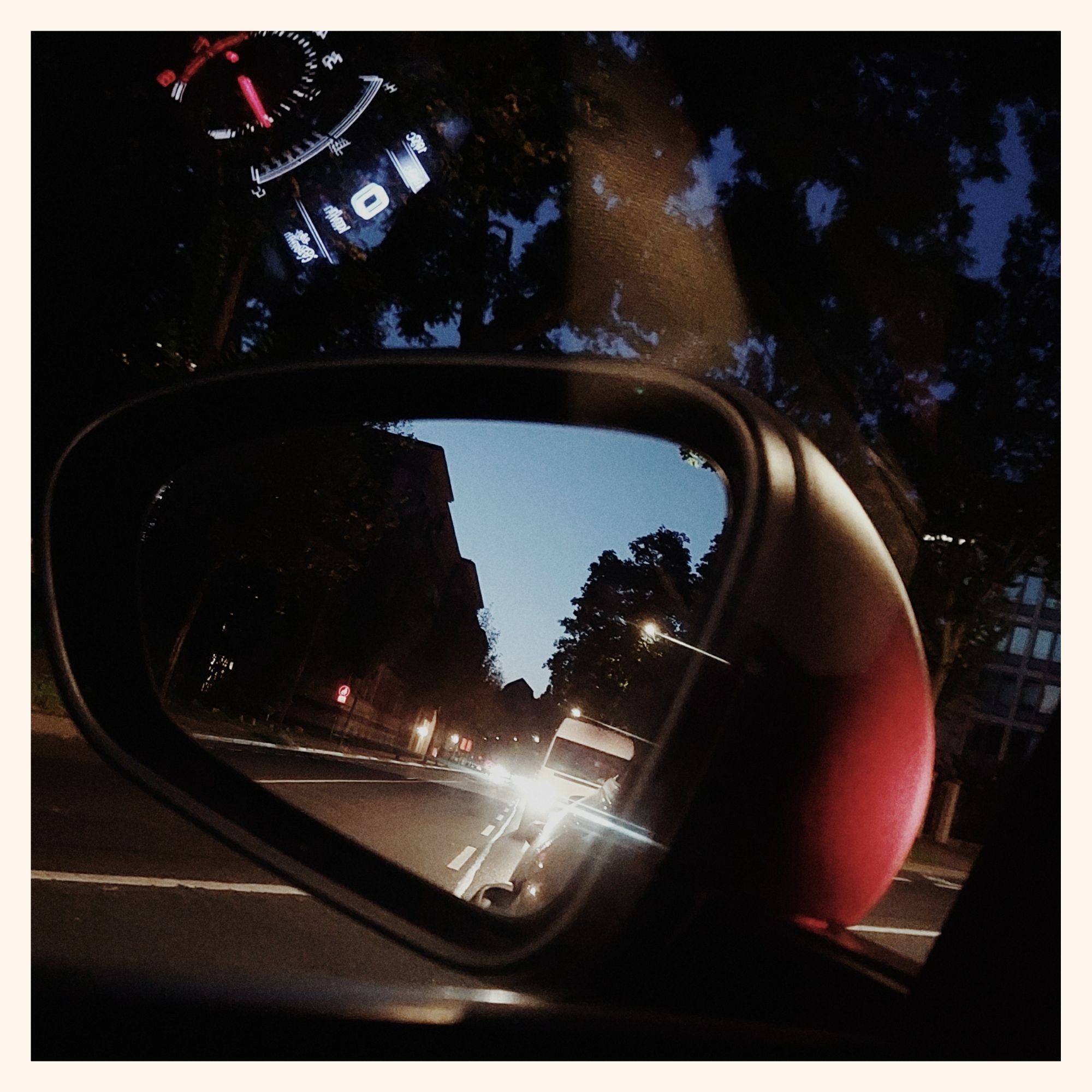 Bright dusk sky in a rear view mirror. 