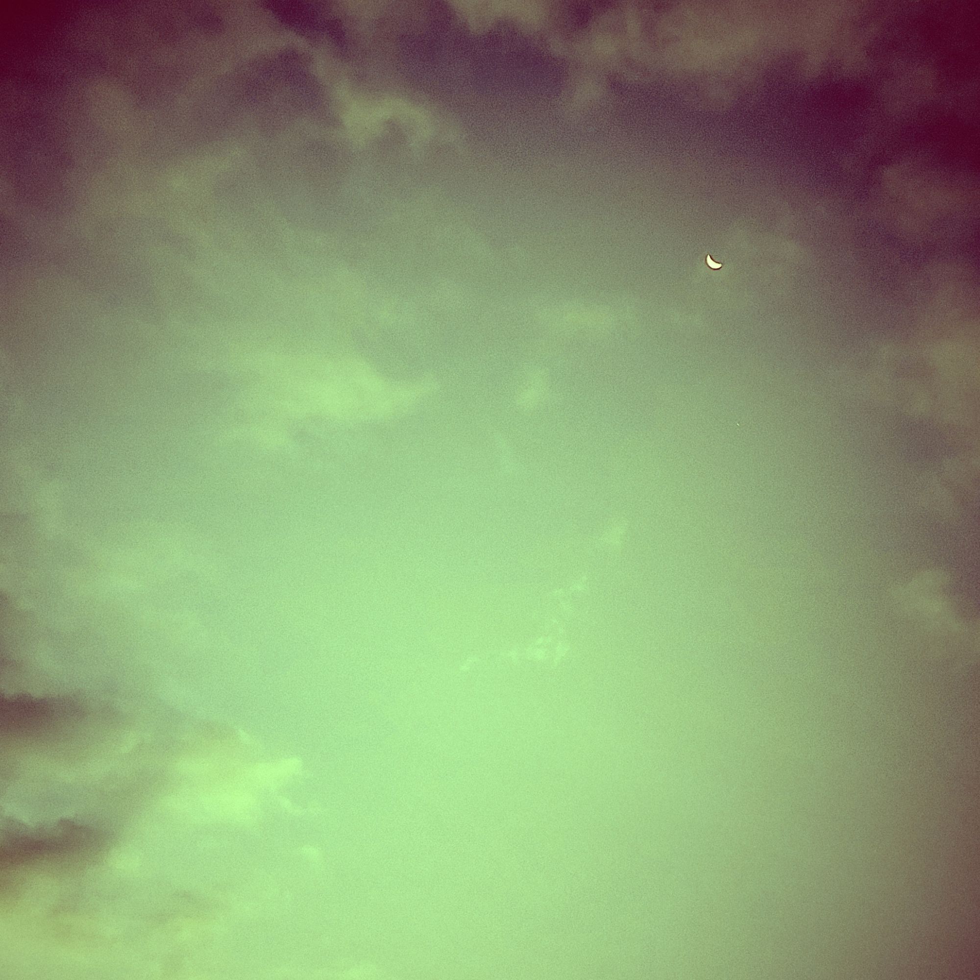 Colour-effect morning clouds. A quiet sky. A small moon on the upper right.